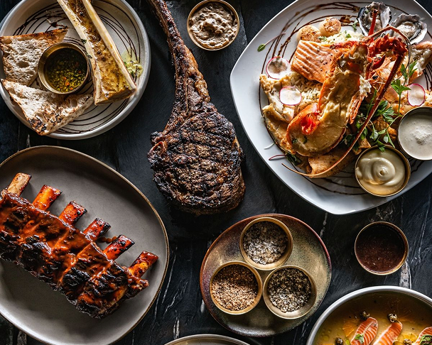 Grilled meats, ribs and side dishes on a table