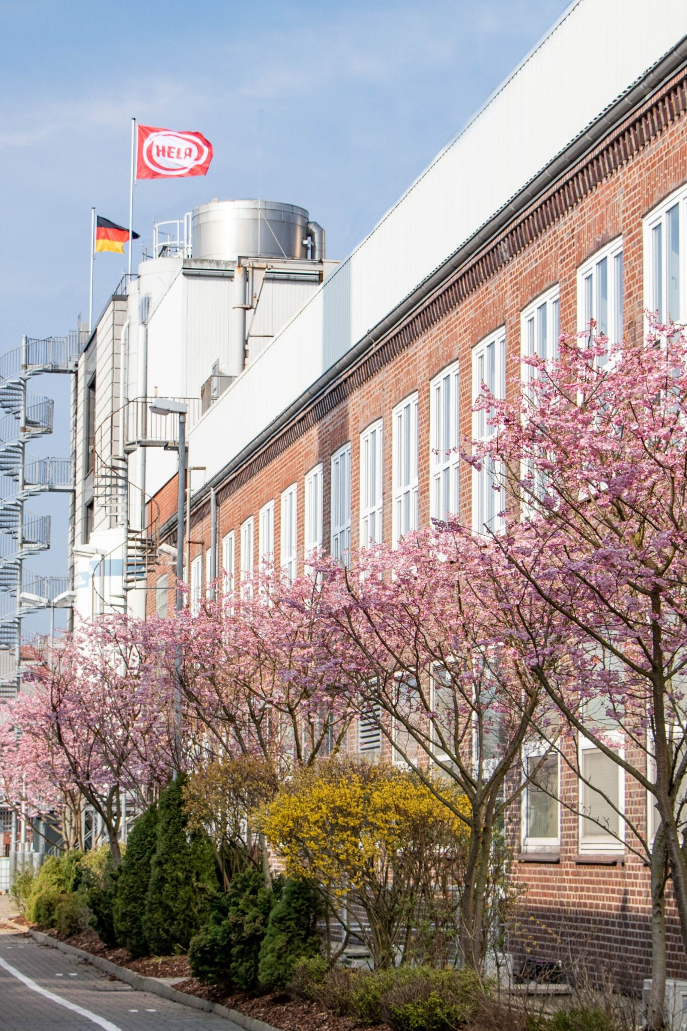 HELA production building with blossoming trees in front