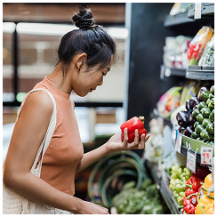 A woman choosing vegetables in a supermarket