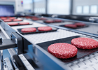 Burger patties on a food production conveyor