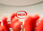 HELA logo with red product bottles in the foreground