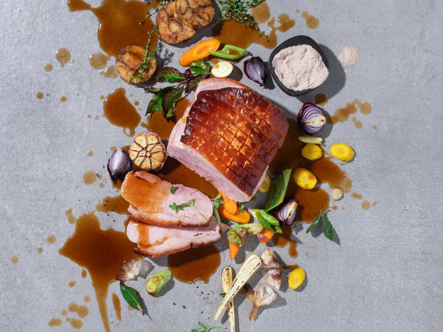 Sliced roast meat with vegetables and sauce, seen from above