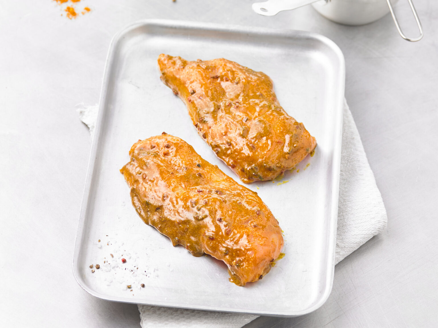 Marinated chicken portions on a tray
