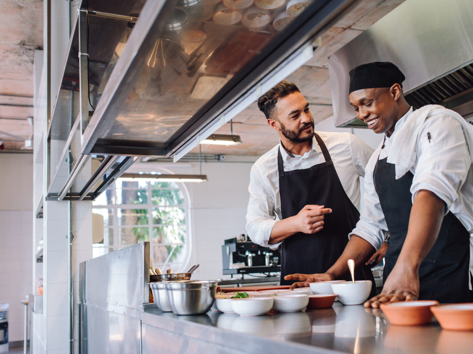 Two chefs preparing dishes in a commercial kitchen