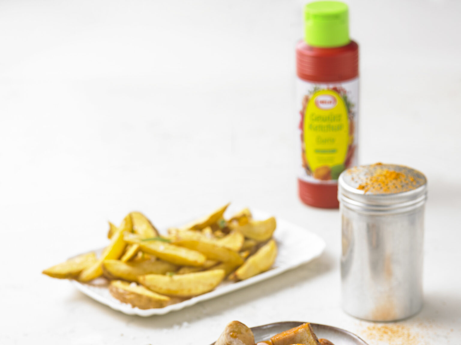 Seasoned fries with HELA sauce and a seasoning shaker