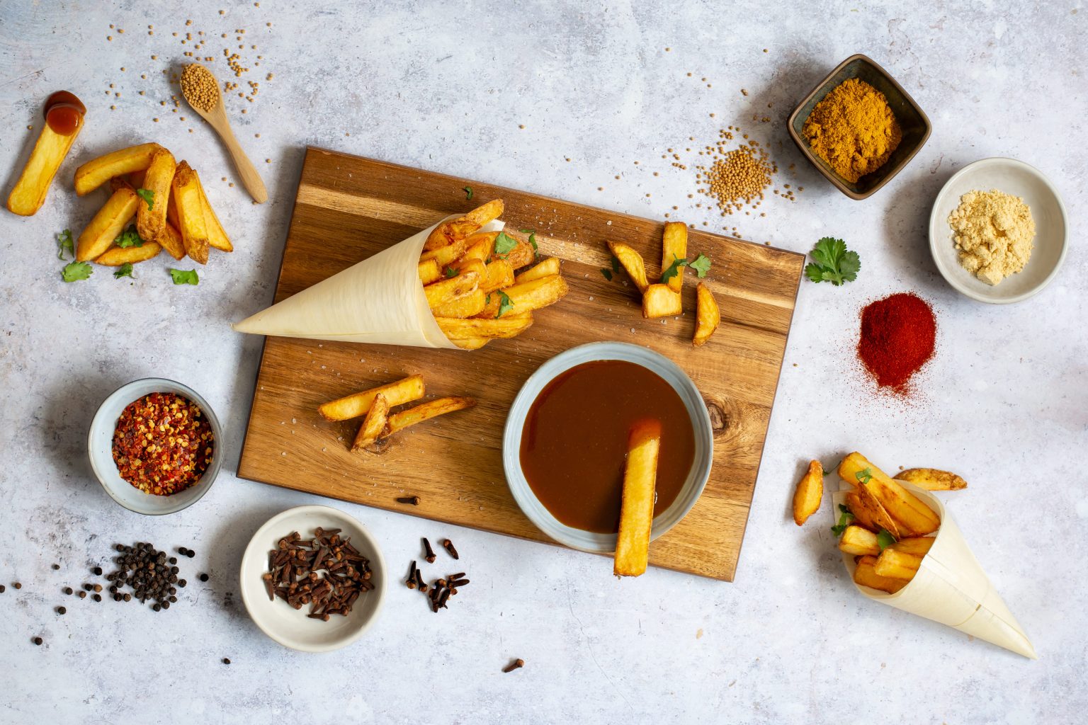 Fries, sauces and small bowls of seasoning ingredients
